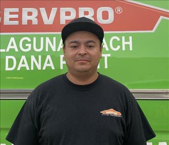 male employee standing in front of a green wall