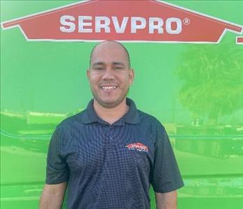 male employee standing in front of a green wall