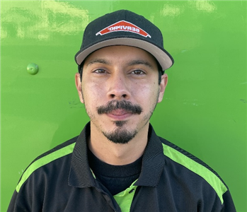 male employee standing in front of a green wall