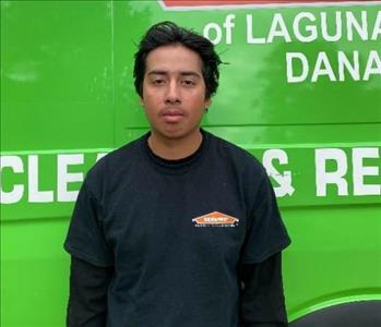 male employee standing in front of a green wall