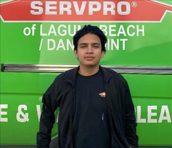 male employee standing in front of a green wall