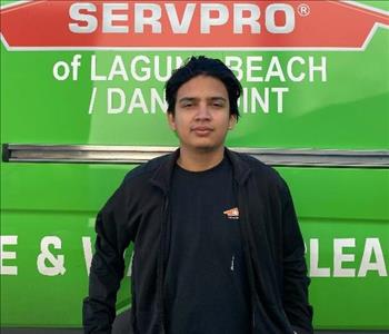 male employee standing in front of a green wall