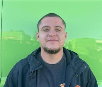 male employee standing in front of a green wall