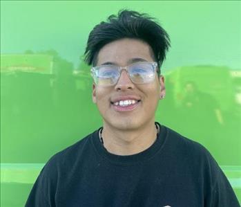 male employee standing in front of a green wall