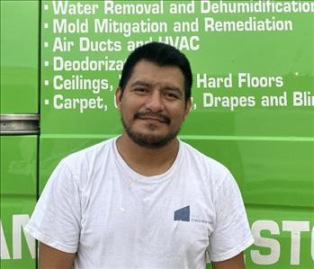 male employee standing in front of a green wall