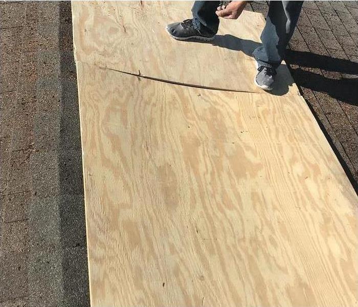 Someone standing on plywood on a roof