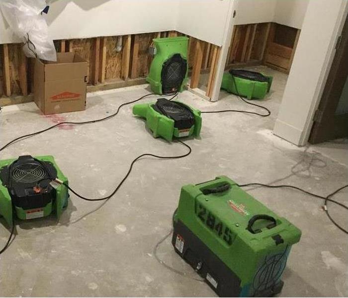 restoration machines are cleaning water damage in a room